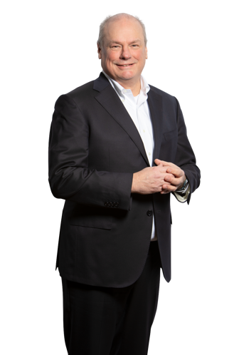 Robin in a black suit with a white shirt stands with his hands in front of him against a plain black background.