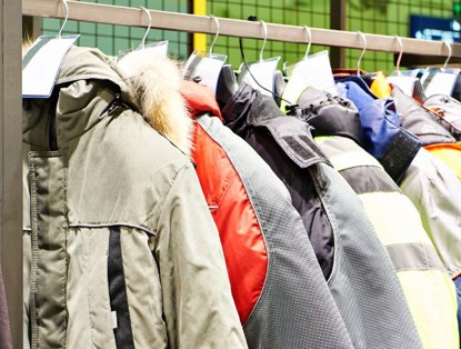 Clothing rack with various winter coats in different colors and styles.