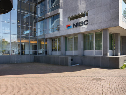 Main entrance of the NIBC office featuring large windows and the NIBC logo on the wall.